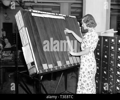 Soziale Sicherheit Geschichte - ein Arbeiter in der Sozialen Sicherheit Bord Aufzeichnungen Büro bei der Arbeit an der "sichtbare" Rack Ca. 1937 oder 1938 Stockfoto