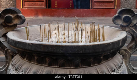 Nahaufnahme eines Altars mit Drachen, Carving, Räuchergefäß, Joss Topf, Räucherstäbchen brennen mit raucht in einem buddhistischen Tempel. Stockfoto