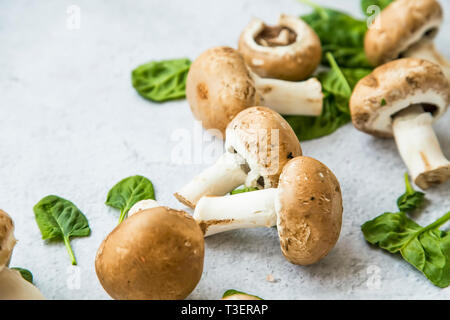 Champignon Pilze closeup mit Spinatblättern, Stillleben, gesundes Gemüse aus ökologischem Anbau Stockfoto
