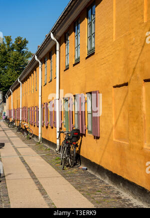 Die markant gelben historischen Cottages in der ehemaligen Marine Kaserne in Nyboder in Kopenhagen. Die Häuser waren ursprünglich Rot und Weiß. Stockfoto