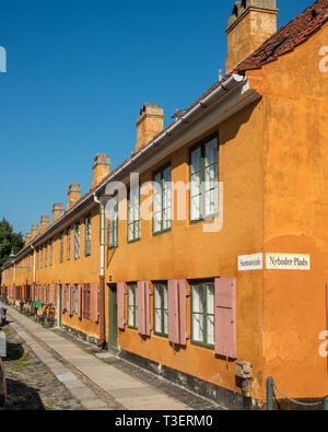 Die markant gelben historischen Cottages in der ehemaligen Marine Kaserne in Nyboder in Kopenhagen. Die Häuser waren ursprünglich Rot und Weiß. Stockfoto