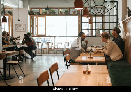 Junge Gruppe von Freunden gemeinsamen Mittagessen in einem Bistro Stockfoto