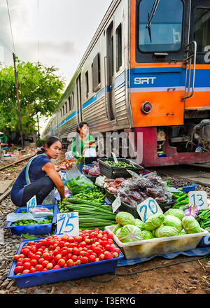 Samutsakorn Provinz, Thailand - 14. März 2019: das tägliche Leben von einem Straßenhändler verkaufen Gemüse zwischen Gleisen als gefährlich vor sich geht. Stockfoto