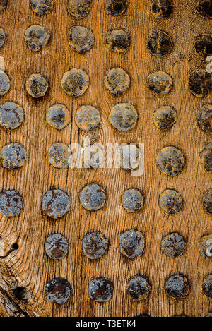 Ein Teil der alten Holz Tor verzierte durch Nägel mit runder Kappe. Vertikale alten hölzernen Textur in Mazedonien Stockfoto