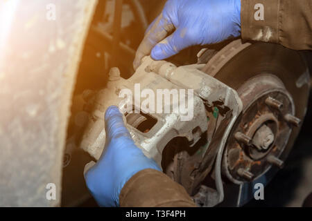 Close up Professional Automechaniker ändern Bremsbeläge vorne im Auto Reparatur Service. Autoworker Reparatur der Bremsen in Garage der Reparatur Service station Stockfoto