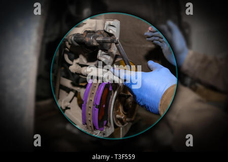 Close up Professional Automechaniker ändern Bremsbeläge vorne im Auto Reparatur Service. Autoworker Reparatur der Bremsen in Garage der Reparatur Service station Stockfoto