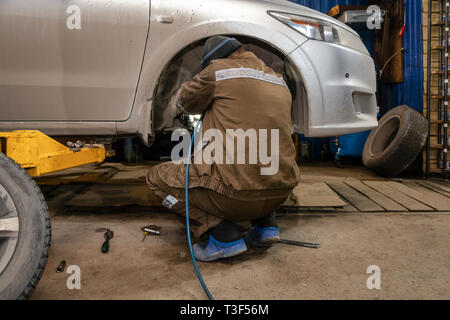 Close up Professional Automechaniker ändern Auto Rad im Auto Reparatur Service. Autoworker, Reifen oder Räder Austausch in der Garage der Reparatur Service s Stockfoto