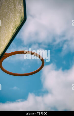 Outdoor Basketballkorb mit blauem Himmel und weißen Wolken hinter Stockfoto