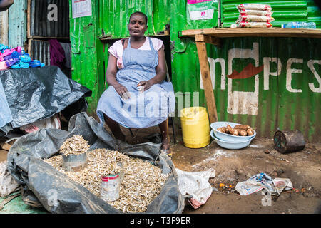 Kisumu, Kenia - März 8, 2019 - die Frau verkauft getrocknete Sardinen in Kibuye Markt, dem größten Open-Air-Markt in Ostafrika Stockfoto