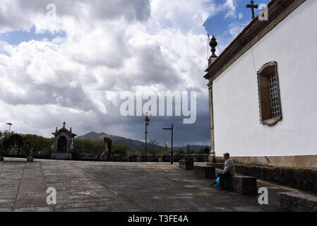 Ponte de Lima, Portugal. 6 Apr, 2019. Ein Mann wird gesehen, Sitzbereich neben dem Santo Antonio Da Torre Velha Kirche. Ponte De Lima ist eine der ältesten Städte von Portugal und für die barocke Architektur bekannt, alte Häuser, historische Sehenswürdigkeiten, schöne Gärten und einen Teil der Vinho verde route Credit: Omar Marques/SOPA Images/ZUMA Draht/Alamy leben Nachrichten Stockfoto