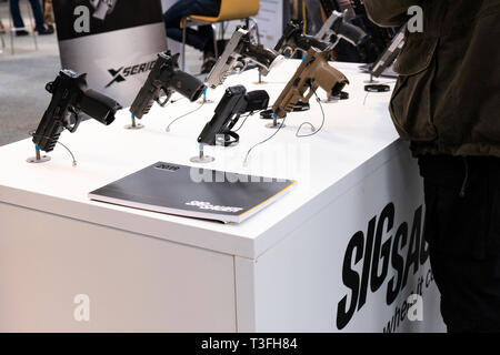 05 April 2019, Schleswig-Holstein, Neumünster: SIG Sauer Pistolen werden auf einer Ausstellung in der Tabelle am "Outdoor 2019 Jagd & Natur'Messe gelegt. Foto: Frank Molter/dpa Stockfoto