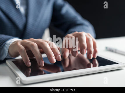 Nahaufnahme der männlichen Hände schreiben auf digitale Tablet Touch Screen. Mann im Anzug am Schreibtisch sitzen und arbeiten bei Tablet Computer. Manager bei workplac Stockfoto