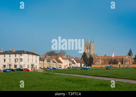 Long Melford Suffolk, Blick auf den Grünen, den Turm der Kirche der Heiligen Dreifaltigkeit und Tudor Krankenhaus (rechts) in Long Melford Dorf, Suffolk, England, UK. Stockfoto