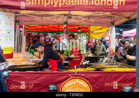 Paella essen in Portobello Road Market in London, UK Abschaltdruck Stockfoto