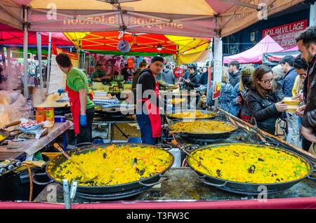 Paella essen in Portobello Road Market in London, UK Abschaltdruck Stockfoto