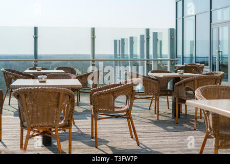 Leere Cafe mit Rattan Korbsesseln und Tischen im Sommer Garten Terrasse im Freien, freier Speicherplatz. Tisch und Stühle in leeren Cafe. Korbmöbel Stockfoto