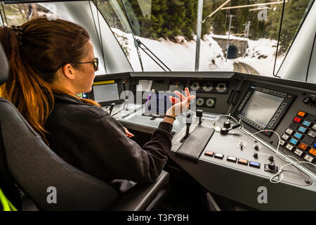 Zugfahrerin in der Schweiz. Die Zugfahrt in einem Fahrerhaus der Rhätischen Bahn ist ein ganz besonderes Erlebnis und kann im Voraus gebucht werden Stockfoto