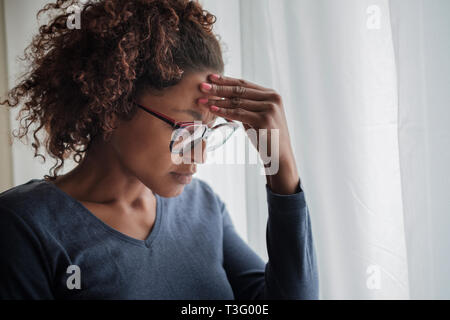 Portrait von nachdenklich schwarze Frau stand neben Fenster
