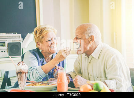 Gerne älteres Paar essen Pfannkuchen zum Frühstück in einer Bar Restaurant - alte Menschen Spaß genießen Mahlzeit am Mittag Stockfoto