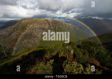 Bunte Regenbogen auf Berglandschaft Stockfoto