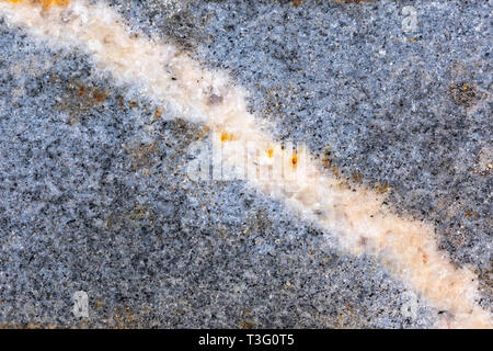 Die Textur einer Granitfelsen mit einer Linie der Mineral durch es Diagonal Stockfoto