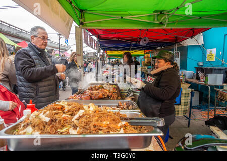 Ein Mann kauft Lebensmittel aus Street Food vendor im Acklam Dorf auf der Portobello Road in Notting Hill, London, UK Stockfoto