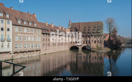 Heilig-Geist-Spital (Hospiz zum Heiligen Geist) in der Altstadt von Nürnberg. Blick von der Brücke auf der auf der Pegnitz - Nürnberg, Deutschland Stockfoto