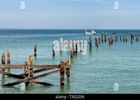 Bleibt der alte Pier in Swanage mit einem Boot im Hintergrund Stockfoto