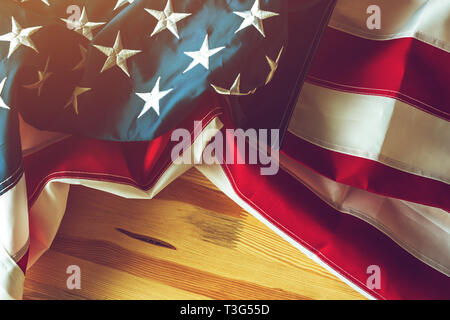 USA-Flagge auf hölzernen Hintergrund zerknittert, amerikanische Fahne mit gesticktem Sterne und Streifen Stockfoto