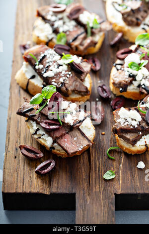 Steak Bruschetta mit Feta und Oliven Stockfoto