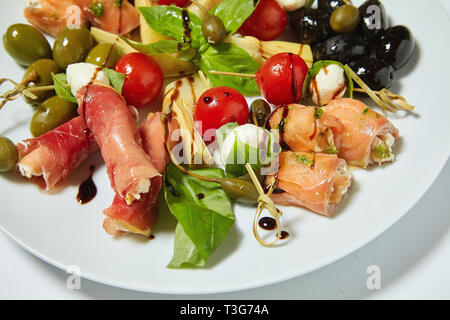 Gemüsesalat mit Oliven, Kapern, Fleisch und Brötchen. Isoliert auf weißem Hintergrund. Stockfoto