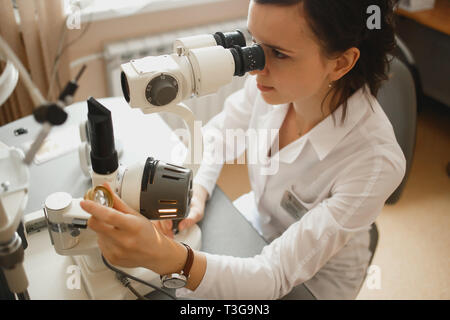 Attraktiven weiblichen Arzt Augenarzt überprüft das Auge Vision von Patienten in der modernen Klinik. Stockfoto