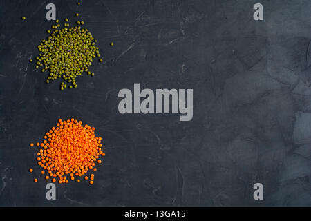 Blick von oben auf die natürlichen Müsli Essen bestand aus roten und grünen Bohnen Linsen auf dunklem Hintergrund. Gesunde Ernährung Konzept. Stockfoto