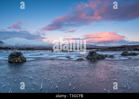 Sonnenaufgang über einen gefrorenen Lochan na h-achlaise auf Rannoch Moor in der Nähe der Eingang zu Glencoe in die schottischen Highlands Stockfoto