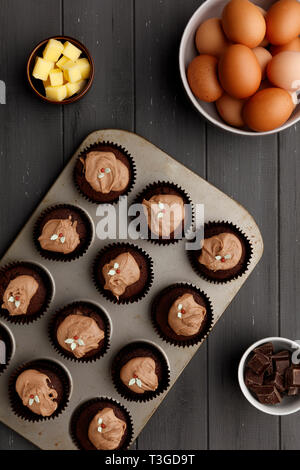 Fee Kuchen in Backform mit Zutaten, die auf einen aufgeregten grau Holz- Hintergrund, Schuß von oben Stockfoto