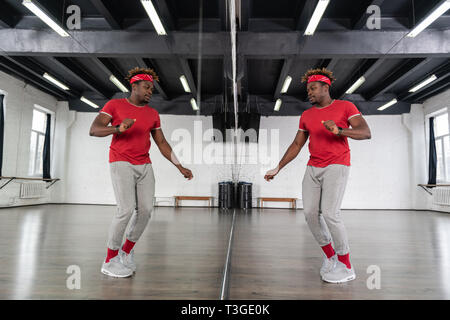 Active fit Mann im sportlichen Outfit tanzen vor dem Spiegel Stockfoto