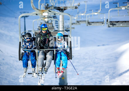 Glückliche Menschen, Kinder und Erwachsene, Skifahren an einem sonnigen Tag in den Tiroler Bergen. Kinder, die Spaß beim Skifahren Stockfoto