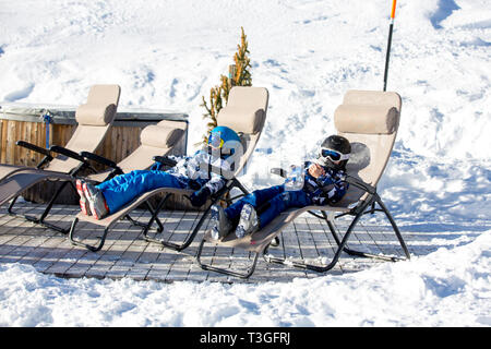 Glückliche Menschen, Kinder und Erwachsene, Skifahren an einem sonnigen Tag in den Tiroler Bergen. Kinder, die Spaß beim Skifahren Stockfoto