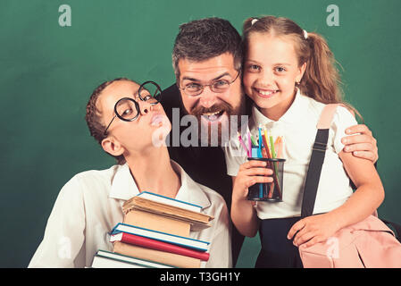 Ein Mädchen trägt einen schweren Stapel Bücher. Lehrer und Schüler mit schweren Buch Sammlung in den Händen Stapel Stockfoto