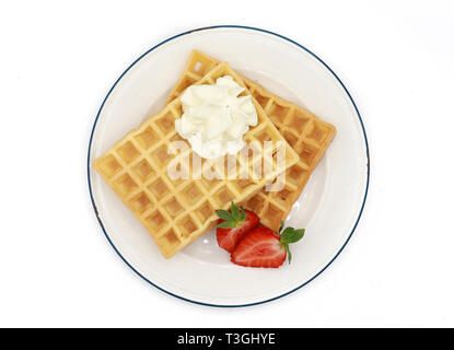 Frische belgische Waffeln mit Erdbeeren und Schlagsahne auf einem Schild auf weißem Hintergrund Stockfoto