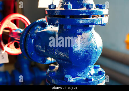 Großer Durchmesser gas Rohr-T-Stück close-up mit einem roten Ventil am Ende in der Unschärfe. Industrielle Hintergrund. Stockfoto