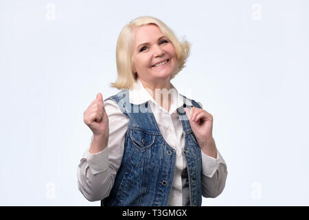 Lächelnd Senior European blonde Frau an der Kamera schaut. Stockfoto