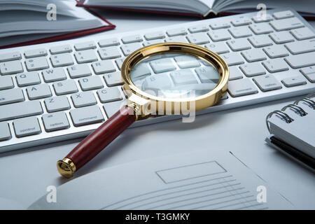 Lupe auf der PC-Tastatur Suche Technologie Konzept Stockfoto