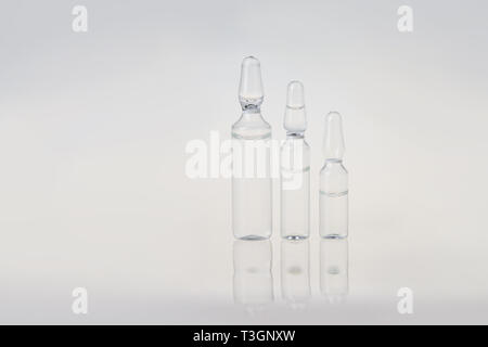 Raw von Ampullen mit Wasser für Injektionszwecke. Pause - Dichtung Glas Ampullen mit Medizin Flüssigkeit auf grauem Hintergrund. Stockfoto