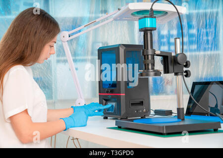 Arbeiterin in der Steuerung von Harz LCD/DLP/SLA 3D Drucker in Technology Lab Stockfoto