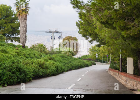 Blick von der Straße auf Montjuic Berg, Montjuic Seilbahn und die Stadt Barcelona aus einer Höhe in bewölkten Tag, Spanien Stockfoto