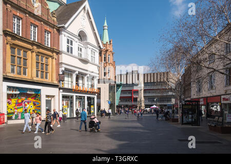 Shops im Leicester High Street mit dem Haymarket Memorial Clock Tower im Hintergrund Stockfoto