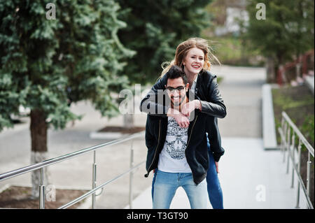 Cool gemischtrassiges Paar posieren. Europäische Mädchen sprang über die Schulter arabischen Mann. Stockfoto