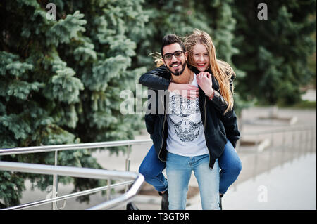 Cool gemischtrassiges Paar posieren. Europäische Mädchen sprang über die Schulter arabischen Mann. Stockfoto