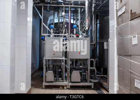 Rohre aus rostfreiem Stahl in der Fabrik. Bau auf die Nahrungsmittelproduktion, abstrakte Industrie Hintergrund. Stockfoto